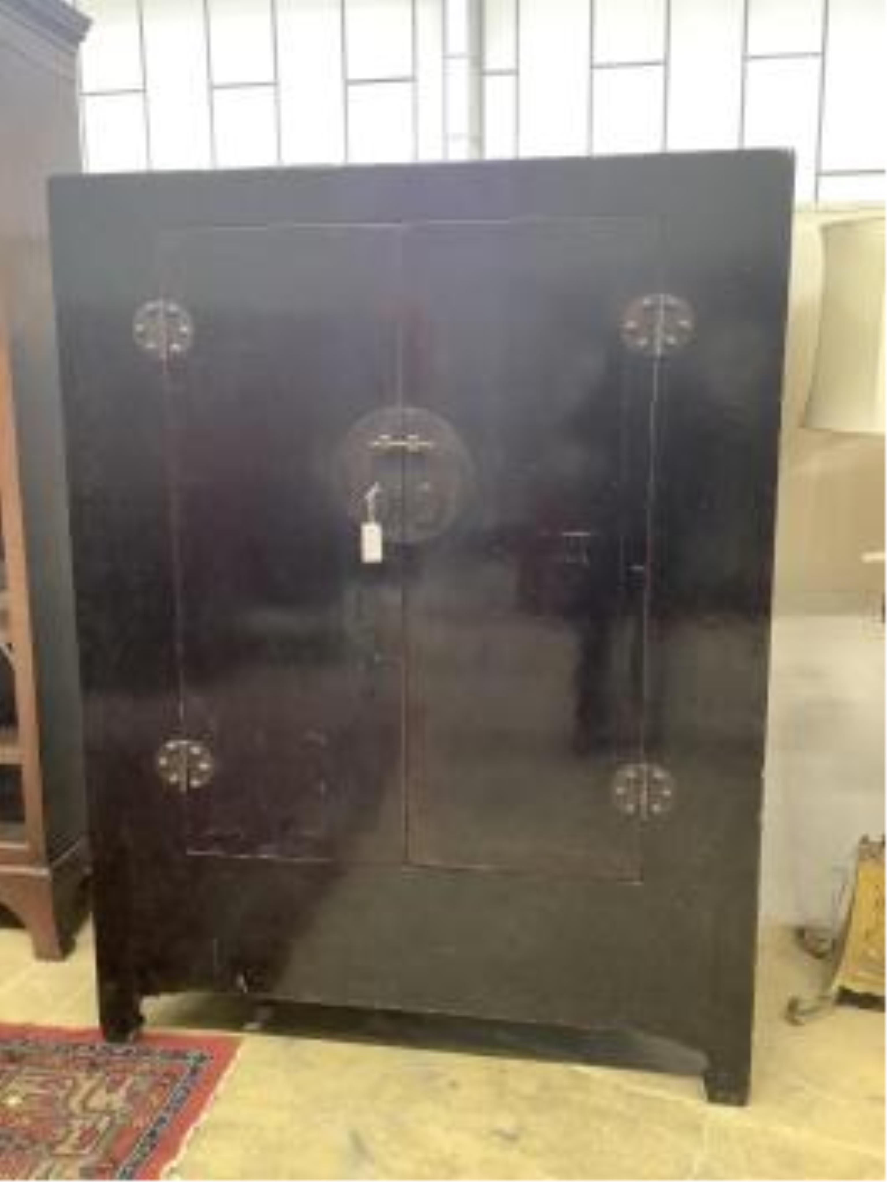 A Chinese two door black lacquer wardrobe, width 135cm, depth 73cm, height 177cm. Condition - fair